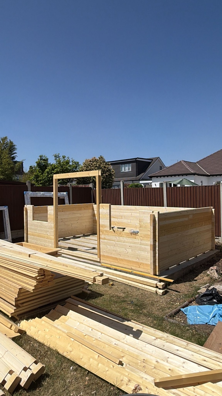 First courses of timber wall logs assembled with the door frame set in place