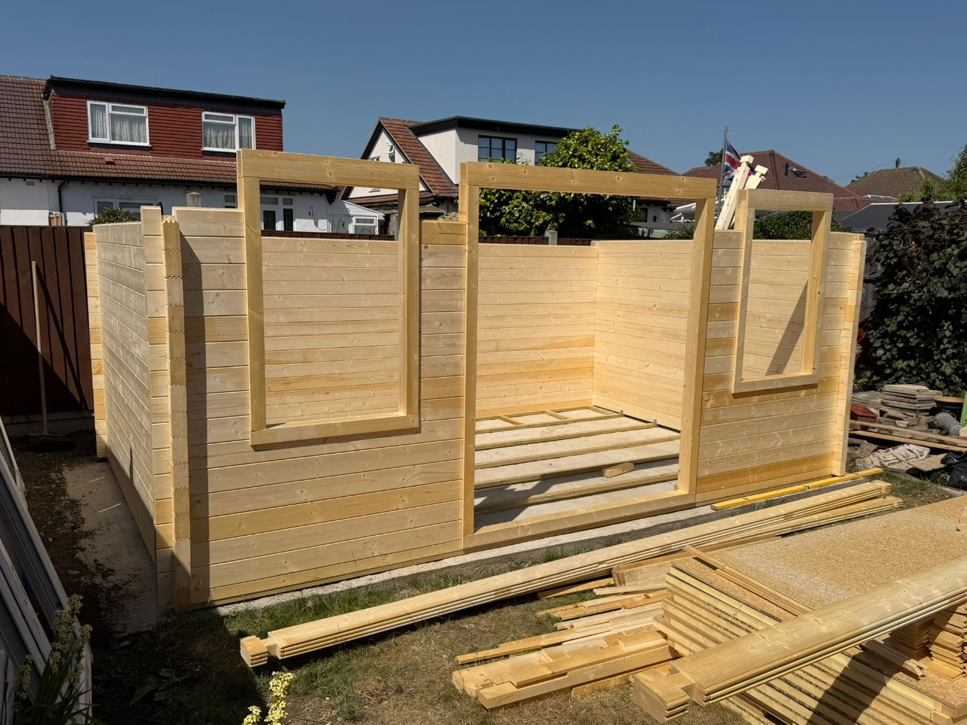 Timber building walls at full height with floor joists laid inside
